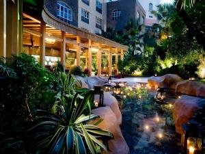 a building with a pond with lights in a courtyard at Hangzhou The First World Hotel in Hangzhou