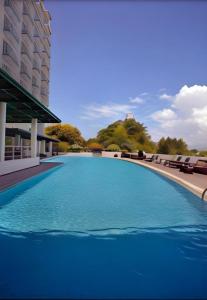 a large swimming pool with blue water in front of a building at Sintesa Peninsula Hotel in Manado
