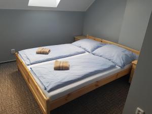 ein Schlafzimmer mit einem Bett mit zwei Kissen darauf in der Unterkunft Penzion U Tří Jasanů in Znojmo