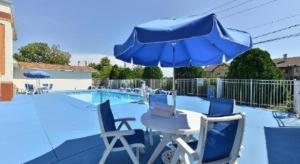 un tavolo e sedie con ombrellone accanto a una piscina di Days Inn by Wyndham St. Charles IL a Saint Charles