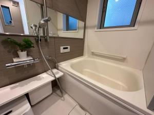 Un baño con bañera blanca y lavabo. en nestay villa tokyo oyama, en Tokio 36 fotos más