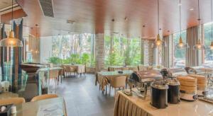 a restaurant with tables and chairs and a large window at Zhuhai Jiali Hotel in Zhuhai