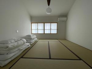 ein Zimmer mit einer Reihe von Matratzen auf dem Boden in der Unterkunft アトレチア祇園宇治別邸プレミアム in Uji
