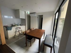eine kleine Küche mit einem Holztisch und Stühlen in der Unterkunft アトレチア祇園宇治別邸プレミアム in Uji + 25 Fotos