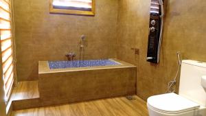 a bathroom with a shower with a toilet and a tub at Windyhill Shalley in Demodera