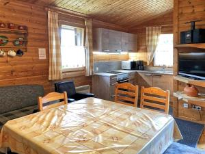 a kitchen with a table and chairs in a room at Ferienhaus Nr 7, Typ B, Feriendorf Jägerpark, Bayerischer Wald in Prackenbach