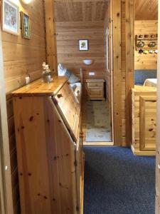 a log cabin with a kitchen and a bedroom at Ferienhaus Nr 7, Typ B, Feriendorf Jägerpark, Bayerischer Wald in Prackenbach