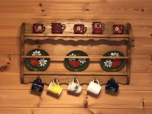 a wall with a shelf with cups and purses at Ferienhaus Nr 7, Typ B, Feriendorf Jägerpark, Bayerischer Wald in Prackenbach