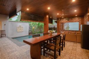 a dining room with a table and a swimming pool at Bima Sakti Homestay Echo Beach Canggu in Canggu