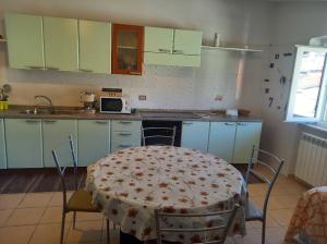a kitchen with a table and a table and chairs at Mansarda Casalina in Casole Bruzio