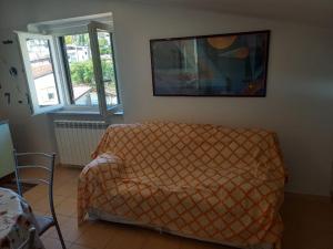 a living room with a bed and a picture on the wall at Mansarda Casalina in Casole Bruzio