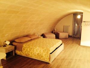 sypialnia z łóżkiem i ceglaną ścianą w obiekcie Le due arcate w mieście Matera