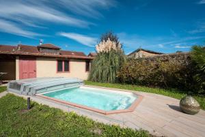 a swimming pool in the yard of a house at Maison avec piscine in Marciac