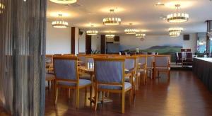 a dining room with a long table and chairs at The Century Seaview Hotel in O-kung