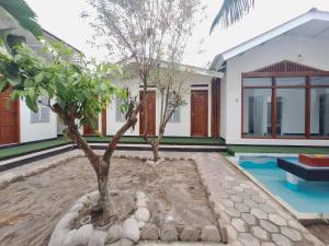 a house with a tree in front of it at Urbanview Bimo Homestay near Sindu Kusuma Edupark Yogyakarta in Jetis