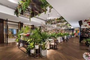 a restaurant filled with lots of potted plants at Shijiazhuang Ximeijin Continental Hotel in Shijiazhuang
