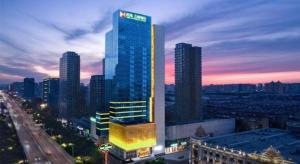 a tall building in a city at night at Shijiazhuang Ximeijin Continental Hotel in Shijiazhuang