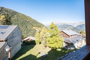 an aerial view of a house with a tree and mountains at Chalet Refuge Loup Blanc Valfréjus in Valfréjus