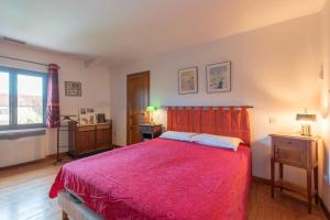 a bedroom with a bed with a red bedspread at Maison avec piscine in Marciac