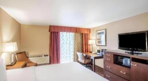 a hotel room with a bed and a desk and a television at White Peak Hotel – Frisco By IHG in Summit Medical Center Heliport