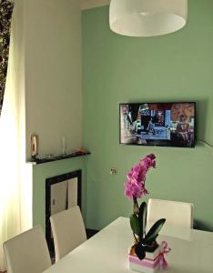 une salle à manger avec une table et un vase de fleurs dans l'établissement Bel Fiore, à San Benedetto del Tronto