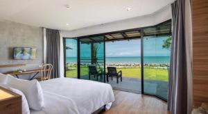 a bedroom with a bed and a view of the ocean at i Tara Private in Phetchaburi