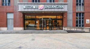 a store front of a brick building with an entrance at Jinjiang Inn Select Shanghai International Tourism and Resorts Zone Chuansha Road Subway Station in Shanghai