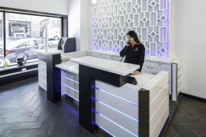 una mujer hablando por un celular en un mostrador en Adante Hotel, a C-Two Hotel, en San Francisco