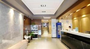 a lobby of a store with a person sitting at a counter at Jinjiang Inn Tai'an Taishan Railway Station in Tai'an
