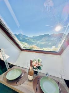 - une table avec une bouteille de vin et une fenêtre dans l'établissement Atypical Studio - Allos, à Allos