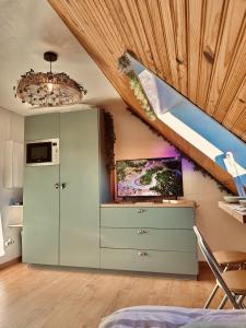 une cuisine mansardée avec un placard vert et un escalier dans l'établissement Atypical Studio - Allos, à Allos