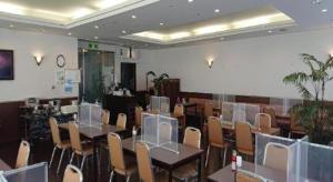 a dining room with tables and chairs in a room at Pearl Hotel Ota in Isesaki