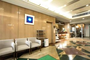 a waiting room with white chairs in a building at Green Hill Hotel Urban in Kobe