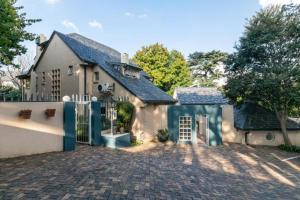 a house with a gate and a brick driveway at Emmarentia Guest House in Johannesburg