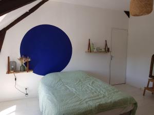 una camera con letto e cerchio blu sul muro di Appartement entre le port et le vieux quartier a La Roche-Bernard