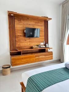 PererenanにあるJasmine River Guest Houseのベッドルーム1室(壁に薄型テレビ付)