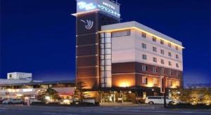 a hotel with a sign on top of a building at Hotel The Grand Court Matsusaka in Tsu