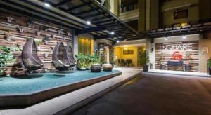 a lobby with a pool in the middle of a building at L Square Hotel in Tarlac