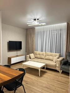 Una sala de estar con un sofá y un televisor. en Riverside Cottage Poti, en Poti