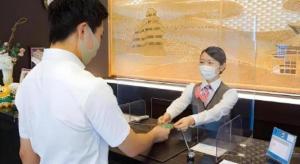 a man and a woman wearing a face mask at Hotel Route Inn Furukawa Ekimae in Osaki