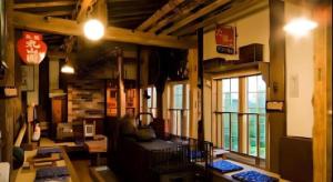 a large room with tables and chairs and windows at Auberge Kitano Dandan in Abashiri
