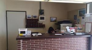 登別市にあるDate Business Hotel Castleの店内のレジカウンターとそこに人が座っている様子