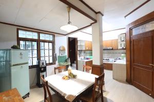 a kitchen with a table and chairs and a refrigerator at Imah Budi Luhur in Bandung