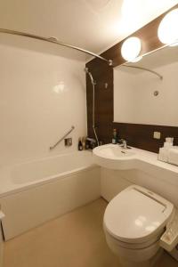 尾道市にあるGreen Hill Hotel Onomichiの白いトイレと洗面台のあるバスルーム