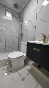 ein weißes Badezimmer mit Toilette und Waschbecken in der Unterkunft Comfort Point Hotel in Bischkek + 14 Fotos