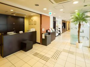 a lobby with a palm tree in the middle of it at Super Hotel Satsuma Sendai in Satsumasendai