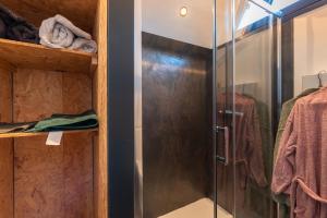 una ducha con puerta de cristal en un baño en La Cabane - Coarraze, en Coarraze