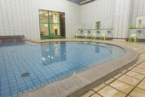 une grande piscine avec des chaises dans un bâtiment dans l'établissement Washigatake Kogen Hotel Rainbow, à Seki 74 autres photos