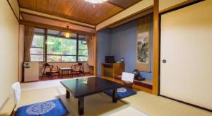a living room with a table and some chairs at Hirayu Prince Hotel in Takayama