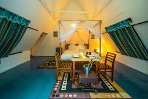 une chambre avec un lit, une table et des chaises dans l'établissement La La Land Resort Goa, à Palolem